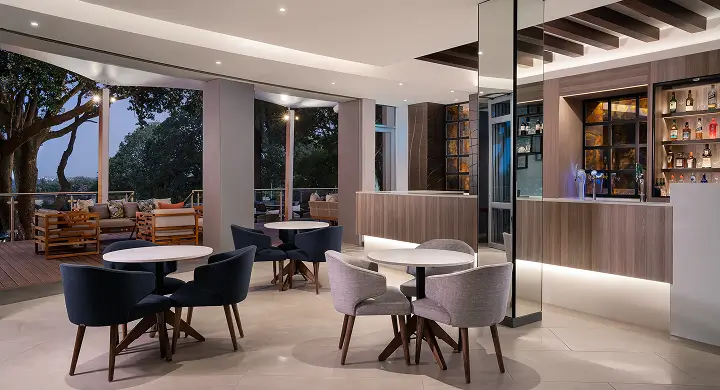Plush, hotel dining room with black and grey tables and chairs